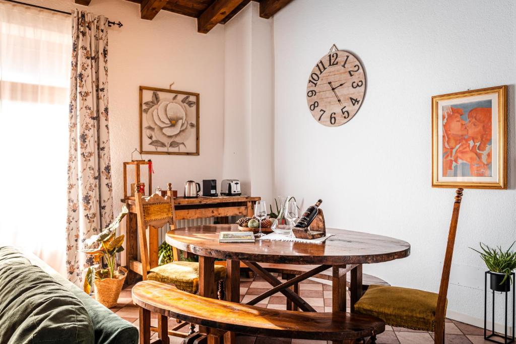 - un salon avec une table et une horloge murale dans l'établissement Dimora Perla di Villa - Historical Wine Retreat near Bernina Express, à Villa di Tirano