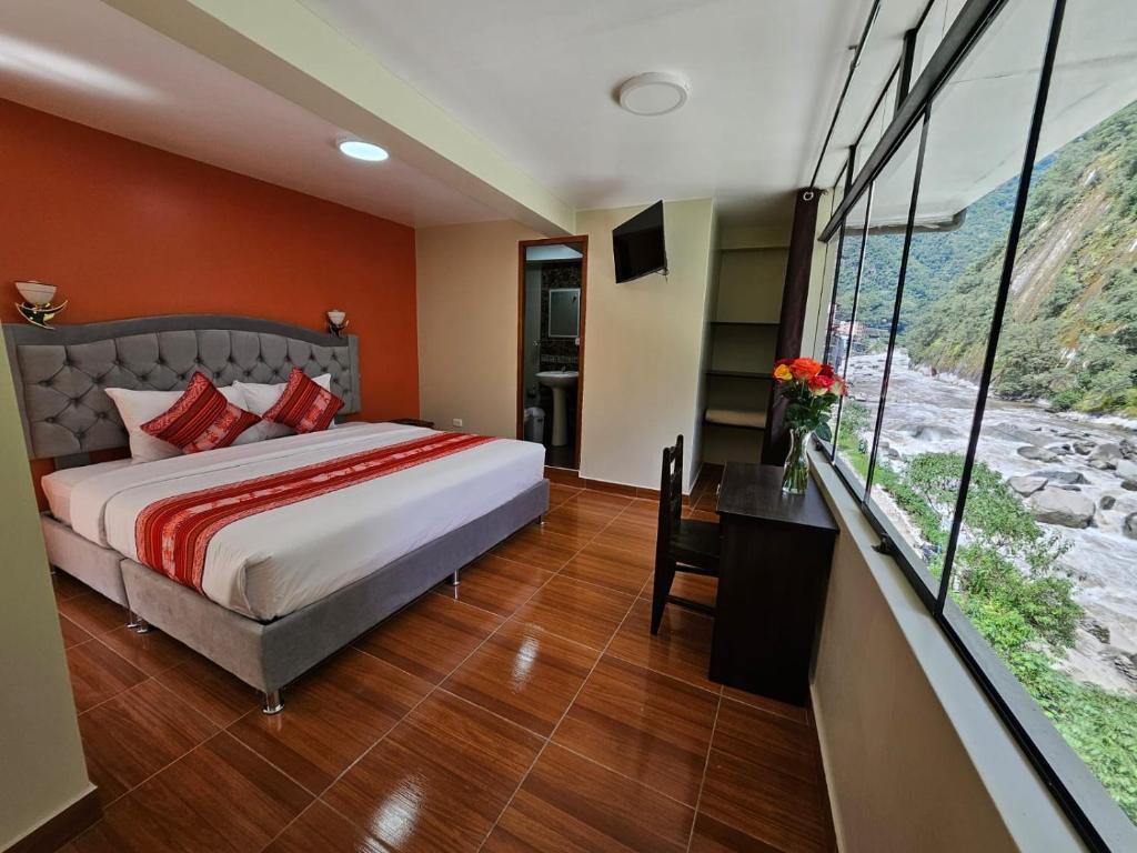 una camera con letto e scrivania con finestra di Hotel Horizonte a Machu Picchu