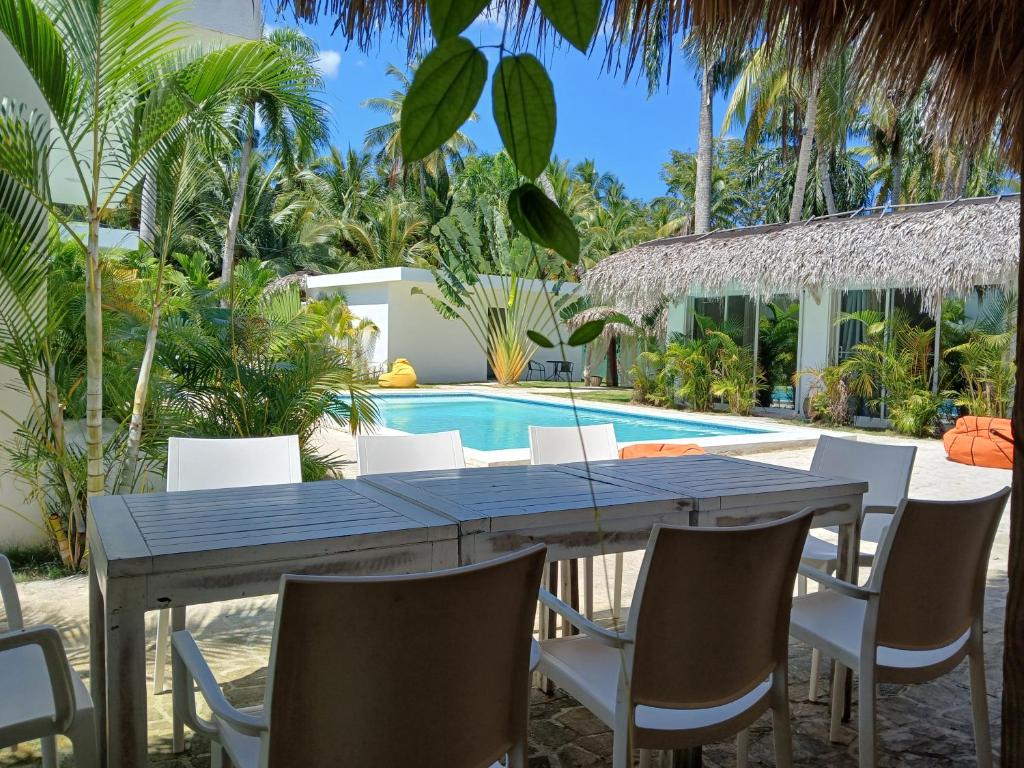 a dining table and chairs in front of a swimming pool at Zodiaco in Las Terrenas in Las Terrenas