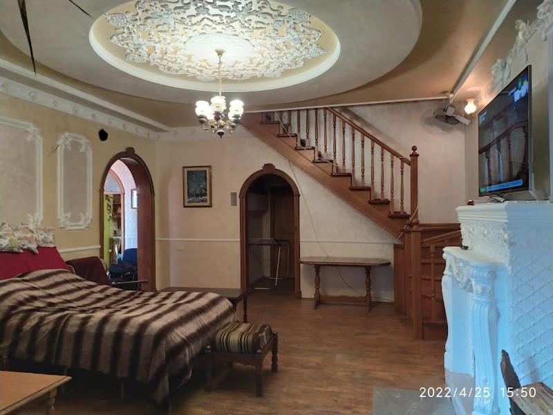 um quarto com uma cama e uma escada com um lustre em Приватний Будинок з Каміном, у Центрі Міста , вул Стрєльцова, 21 em Krivoy Rog