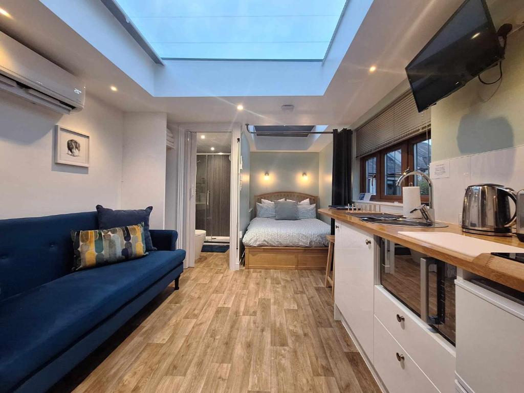 uma sala de estar com um sofá azul e um quarto em La'al Lodge in Kendal (The Gateway to the Lakes) em Kendal