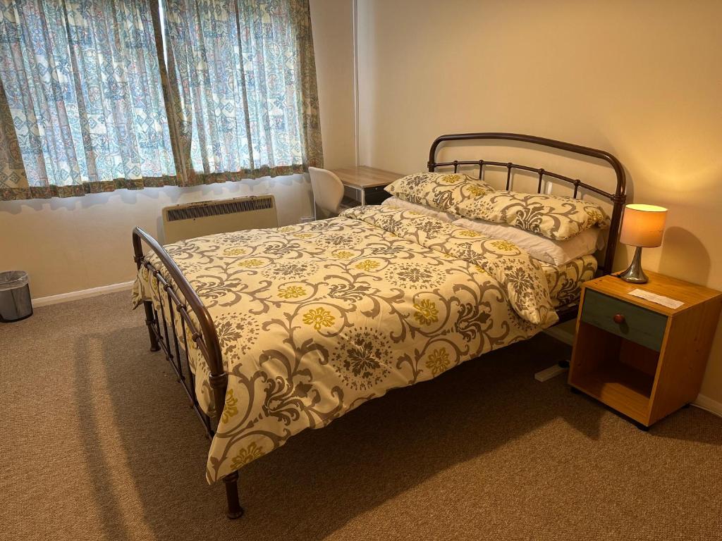 a bedroom with a bed and a lamp on a night stand at 10 Edney Court in Earley