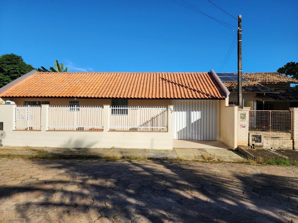 Biały dom z czerwonym dachem w obiekcie Piçarras - 400 metros da praia w mieście Balneário Piçarras