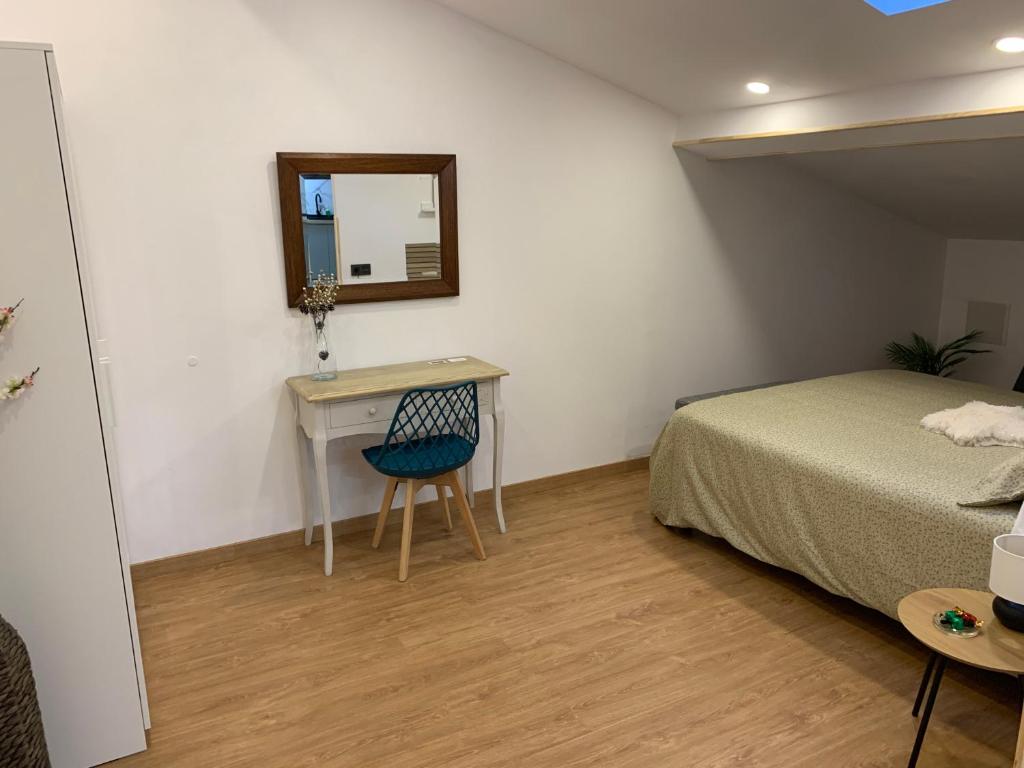 a bedroom with a bed and a desk and a mirror at Apartamentos Talao in San Esteban de Pravia