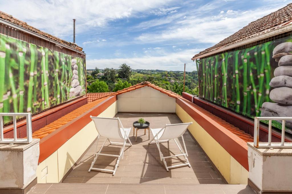 a balcony with two chairs and a table on a roof at Porta 116 in Vila Real