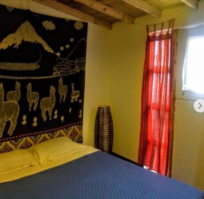 a bedroom with a bed and a painting on the wall at Vieja Aduana in Zipaquirá