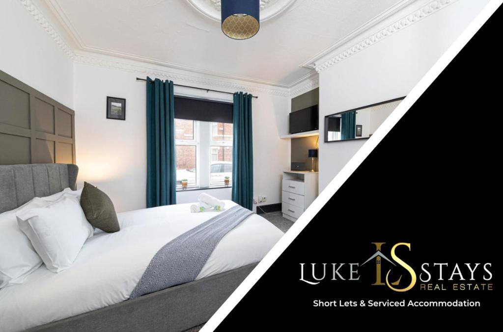 a bedroom with a white bed with blue curtains at Luke Stays - Granville Street in Gateshead