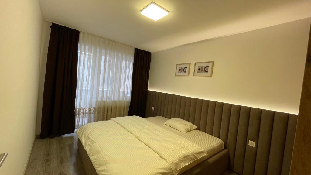 Schlafzimmer mit einem Bett und einem Fenster in der Unterkunft Qendër in Ferizaj