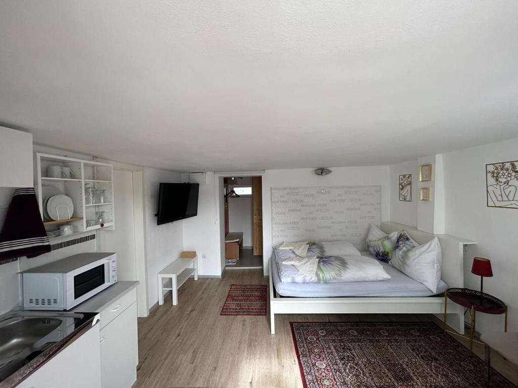 a small white room with a bed in a kitchen at Apartment Harmony in Graz