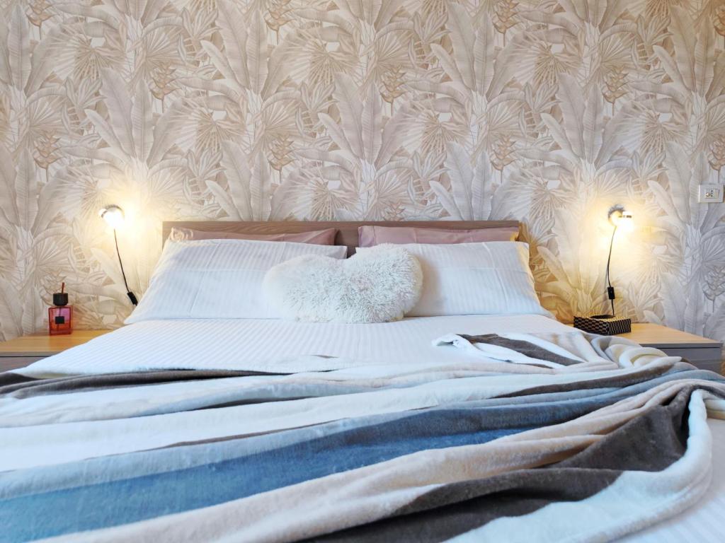 una camera da letto con un grande letto bianco con due lampade di Old City Apartment a Civitavecchia