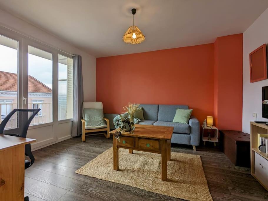 ein Wohnzimmer mit einem Sofa und einem Tisch in der Unterkunft The place to be, parking gratuit in Roanne