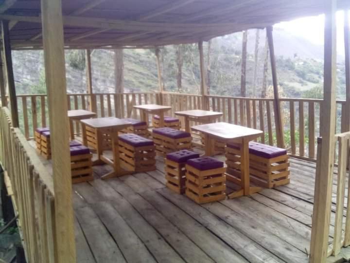 a gazebo with benches and tables on a deck at El salto del gato in Güicán