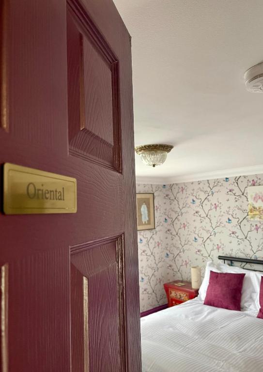 a bedroom with a bed and a wall with a door at Ebenezer's Place in Broadstairs