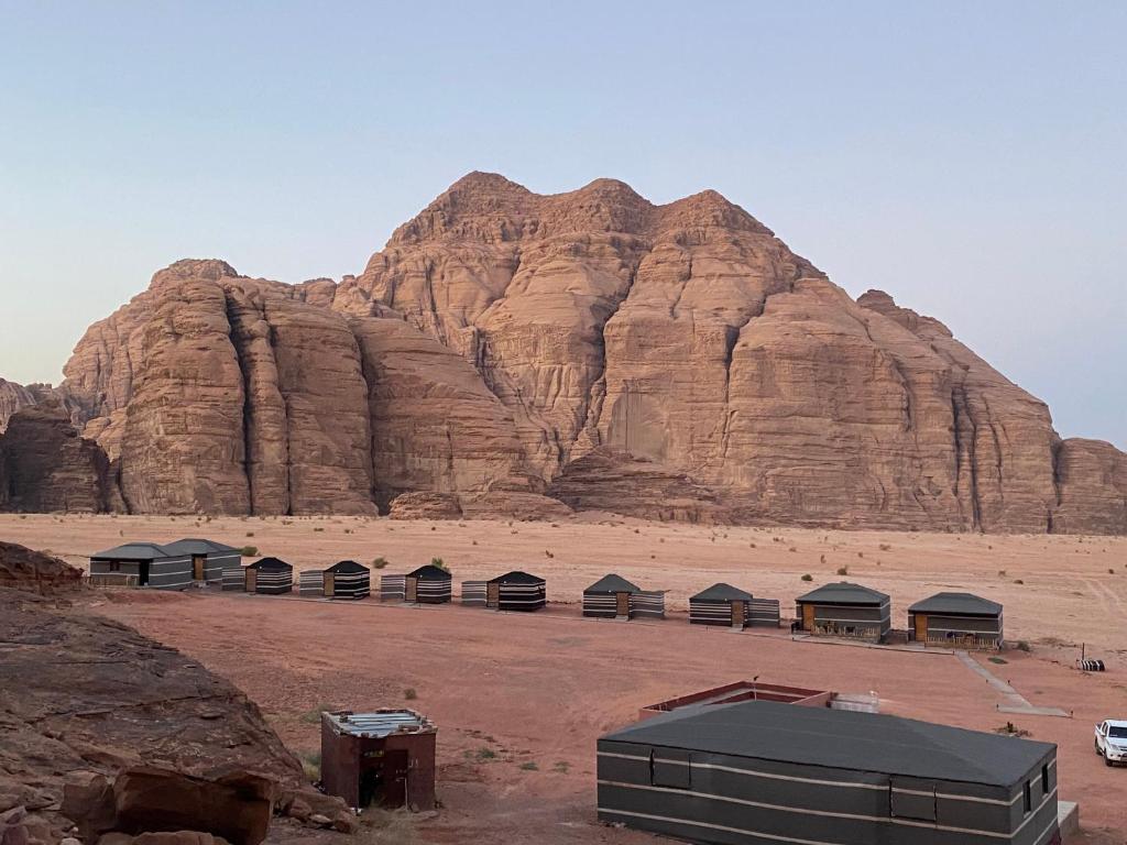 un grupo de tiendas de campaña frente a una montaña en Wadi Rum albasli, en Wadi Rum