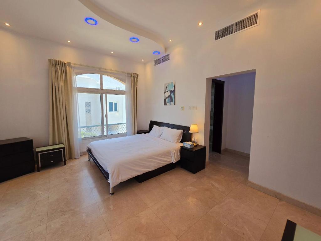 a bedroom with a bed and a large window at Stay Room Jumeriah Dubai in Dubai