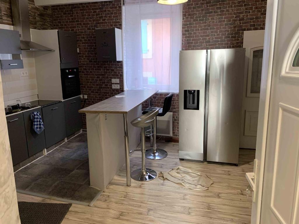 een keuken met een roestvrijstalen koelkast en een aanrecht bij La maison des Artistes in Lavelanet