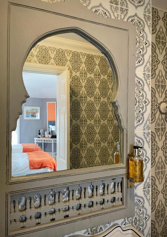 a mirror on a wall in a bedroom at Ebenezer's Place in Broadstairs