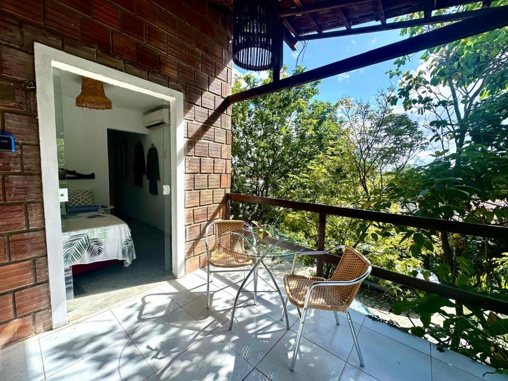 eine Terrasse mit Stühlen und einem Tisch auf einem Backsteingebäude in der Unterkunft Suíte - 05 in Gravatá