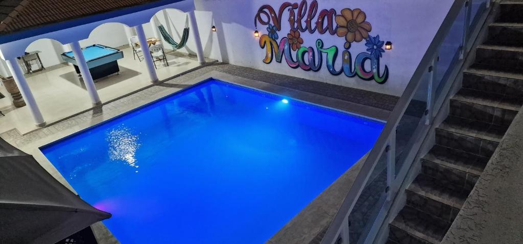 a blue swimming pool next to some stairs at Lujosa y espaciosa Villa María. in Santiago de los Caballeros
