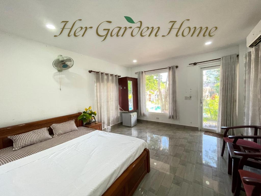 a bedroom with a bed and a sign that reads her garden home at Her Garden Home in Phu Quoc