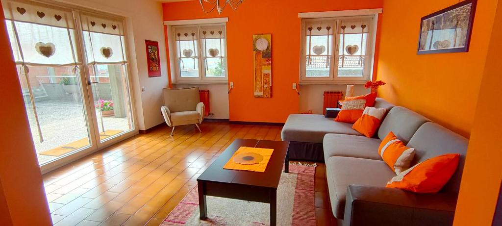 アオスタにあるLa Betulla Appartamento confortevole Wifi e Parking freeのリビングルーム(オレンジ色の壁、ソファ付)