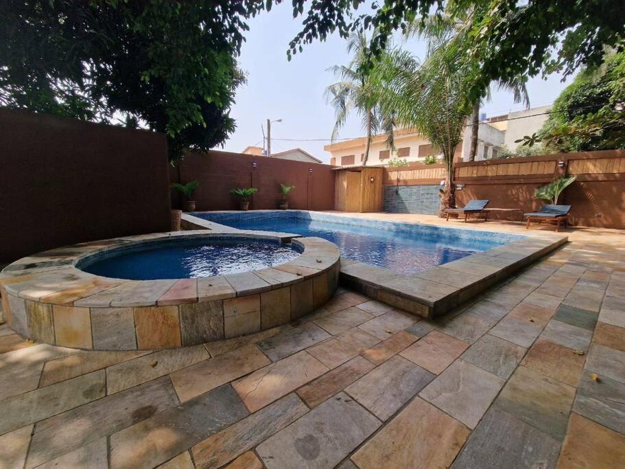 una piscina in un cortile con patio di Maison-Villa de charme à Cotonou a Cotonou