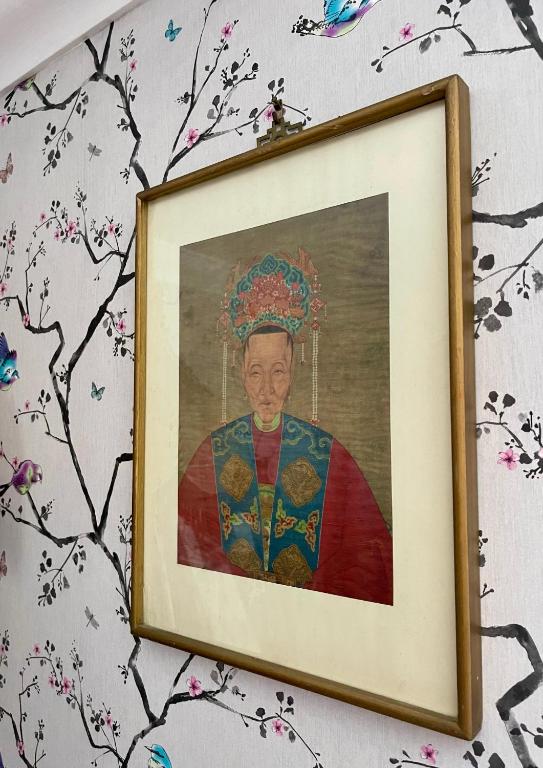 a painting of a woman wearing a crown on a wall at Ebenezer's Place in Broadstairs