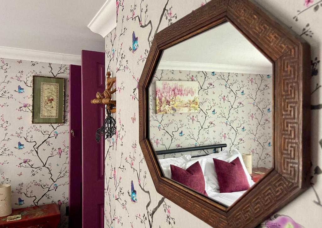 a mirror on a wall in a bedroom at Ebenezer's Place in Broadstairs