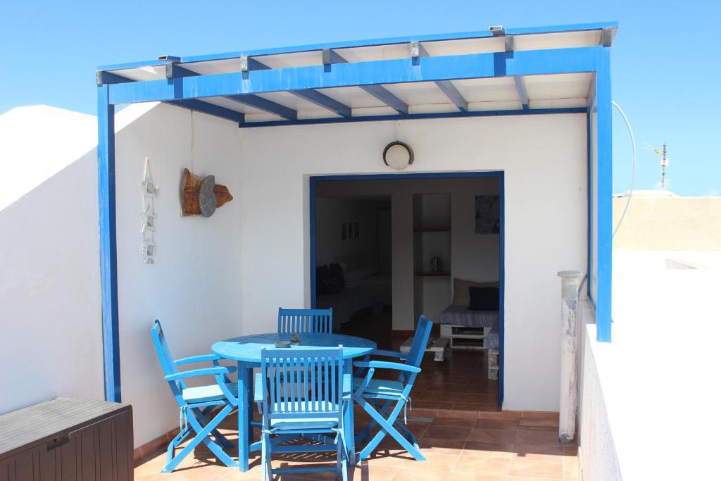 een blauwe tafel en stoelen op een patio bij Casa Noah Famara in Famara