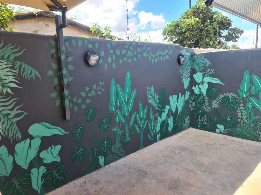 Una pared con un mural de plantas. en Jomana Luxury Apartments, en Lusaka