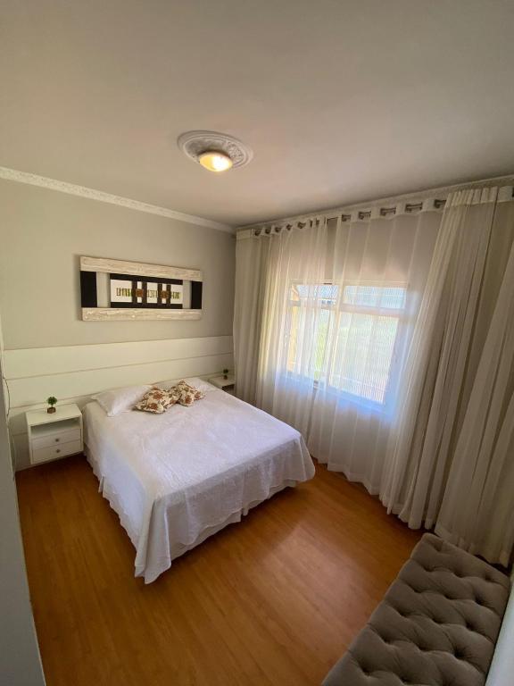 彼得羅波利斯的住宿－Refugio Bela Vista，卧室配有白色的床和窗户。