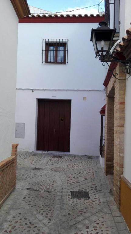 a white building with a brown door and a courtyard at Apartamento Karmo in Carmona