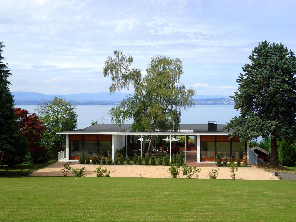 a house with a view of the water at Evian villa with Lake Geneva views in 1960 mid-century modern style in Neuvecelle