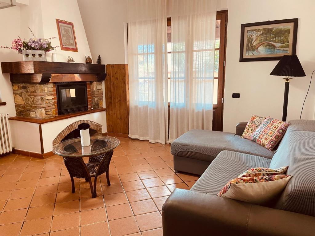 een woonkamer met een bank en een open haard bij The Rustic In Love in Camaiore