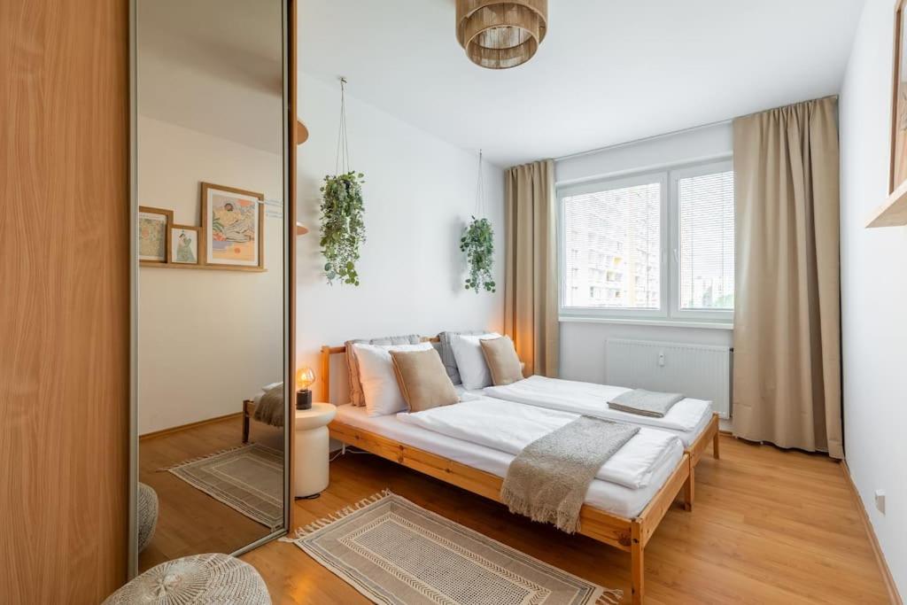 Un dormitorio con una cama y una ventana grande. en Duna Retreat: City Serenity, en Bratislava