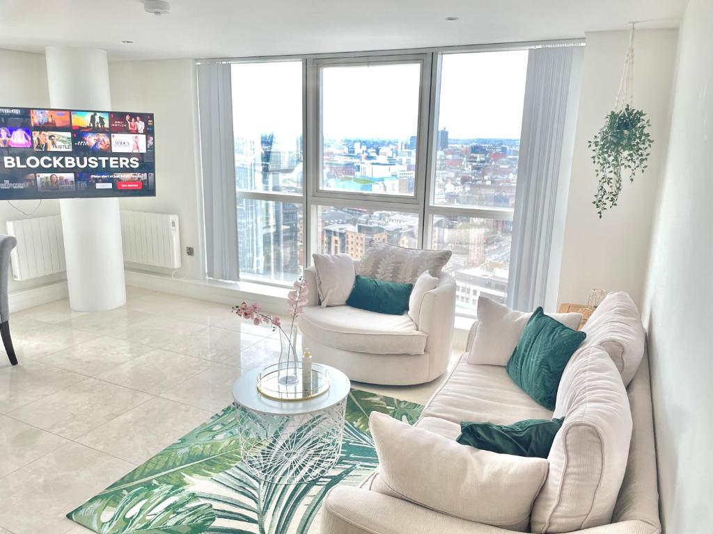 a living room with two white couches and a tv at 22nd Floor Luxury City Centre Apartment in Belfast