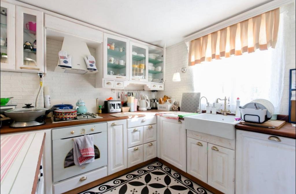 a kitchen with white cabinets and a sink at Ödüllü Tarihi Rum Evi Teraslı in Konak