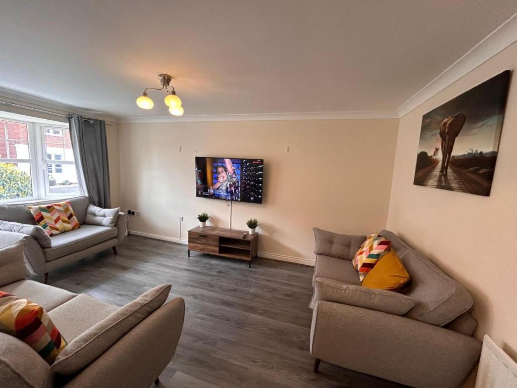 a living room with two couches and a tv at Vyna Place-Close to City Hospital in Nottingham