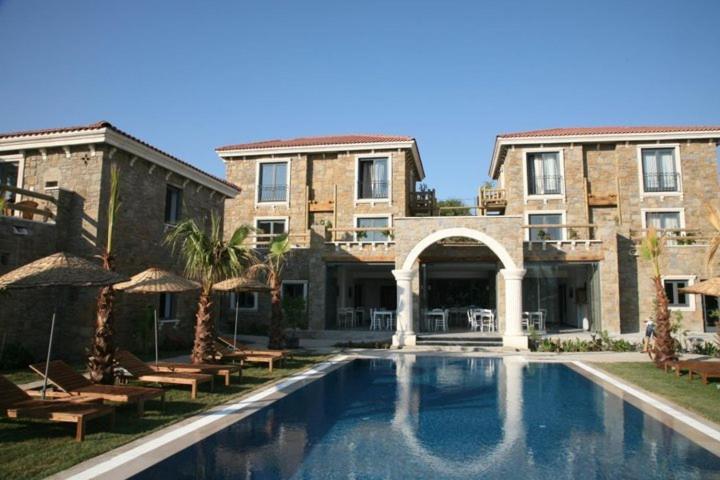 a swimming pool in front of a large building at Anemos Hotel in Gokceada Town