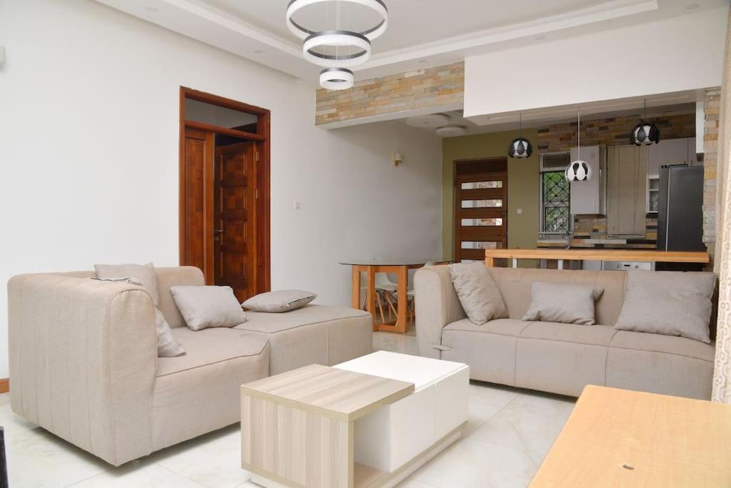 坎帕拉的住宿－Isabirye residence，客厅配有两张沙发和一张桌子