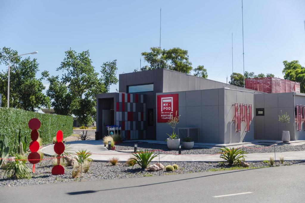 un rendimiento de un edificio con plantas delante de él en My pod Capsule Boutique Airport en Ezeiza