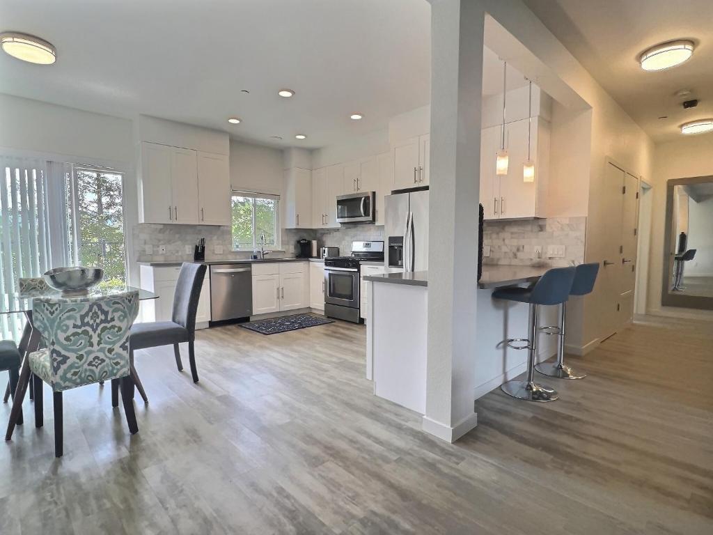 eine Küche mit weißen Schränken sowie einem Tisch und Stühlen in der Unterkunft Sonoma Grove Suites in Sonoma