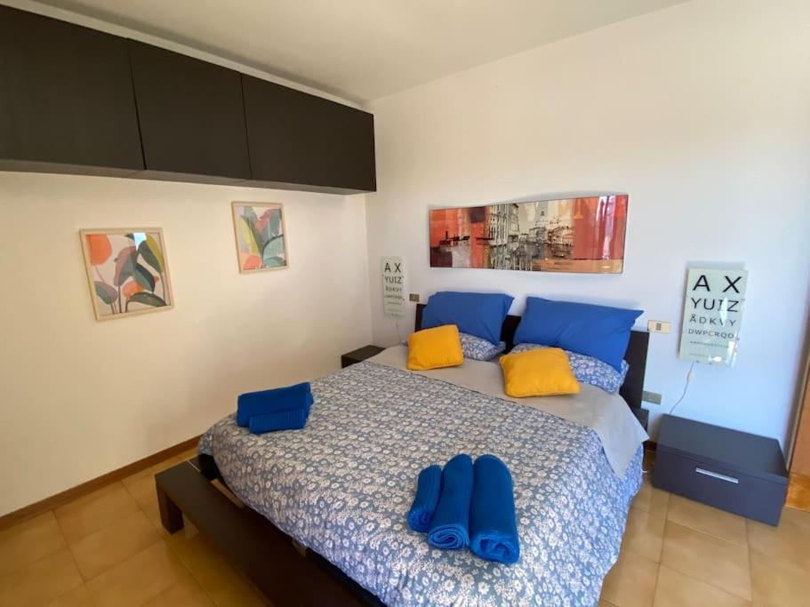 una camera da letto con un letto con cuscini blu e gialli di FrancisHouse-Free parking-Close Hospital Cisanello a Pisa