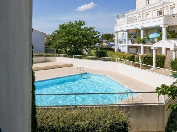 a swimming pool on the side of a building at Grand T3 bien équipé , standing , calme in Vaux-sur-Mer