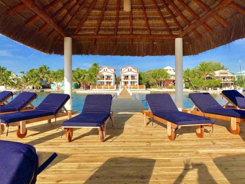 a group of blue lounge chairs on a wooden deck at VeLento Beach Level #9 in Caye Caulker