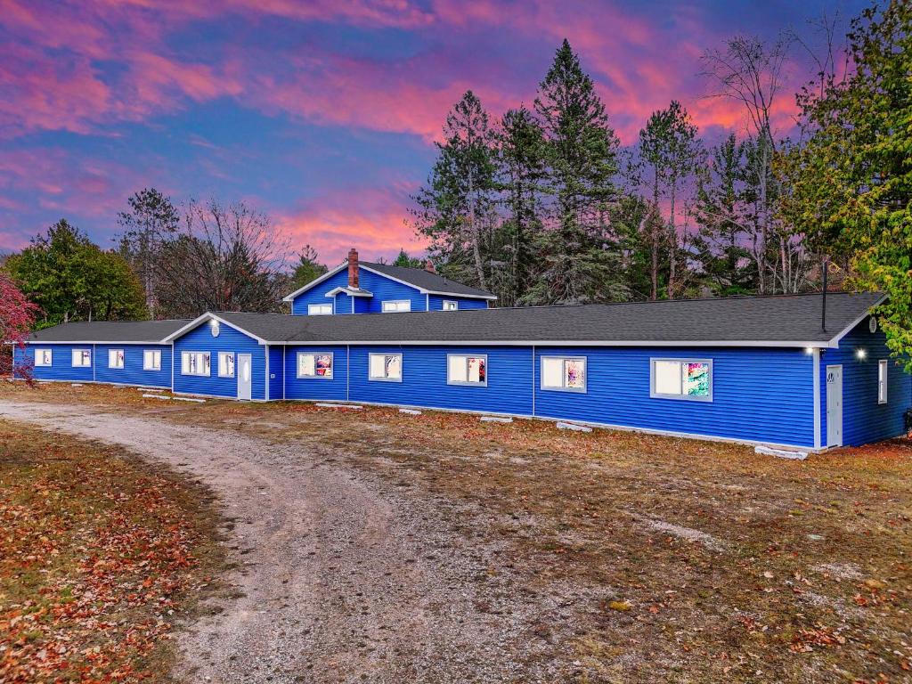 una casa azul en una colina con un camino de tierra en Standard King - Room 4, en Houghton Lake