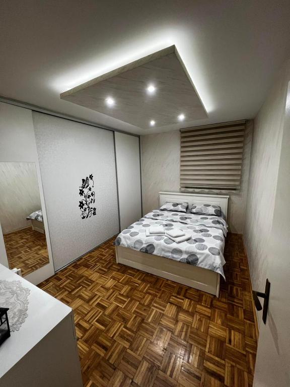 a bedroom with a bed and a wooden floor at GOLD APARTMENT in Berane
