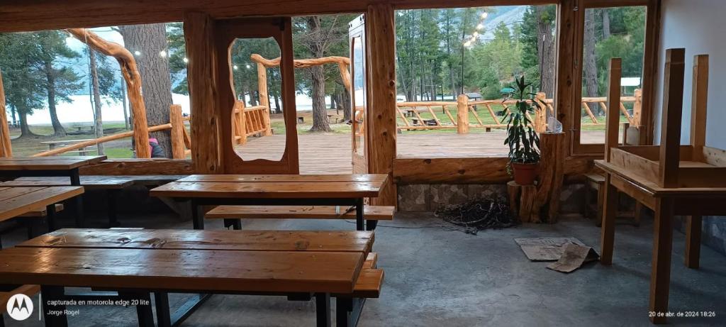 a room with wooden benches and a wooden deck at Camping El Bosque in El Hoyo