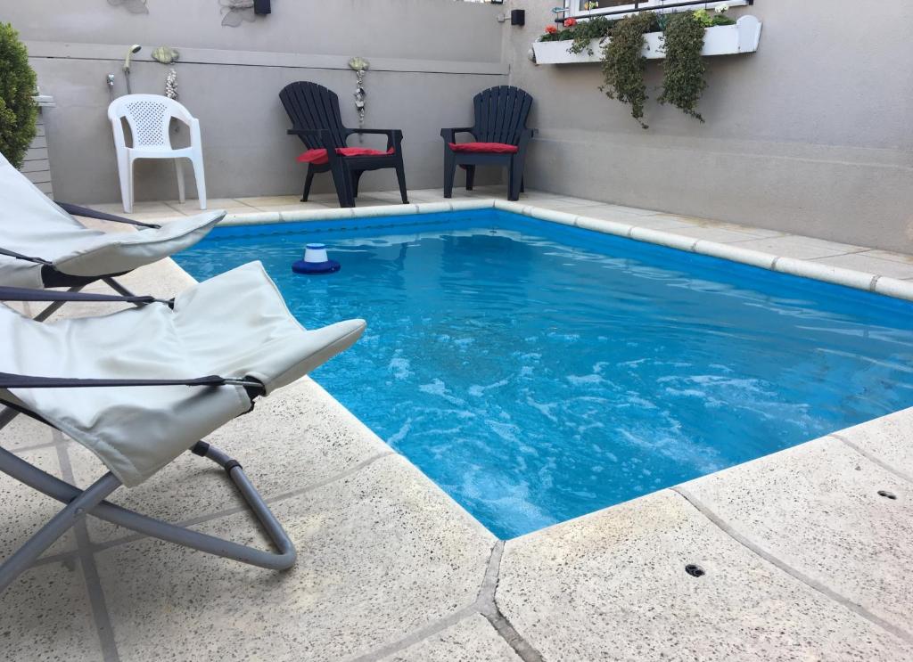 a swimming pool with a chair and a table at ZEN Home in Tandil