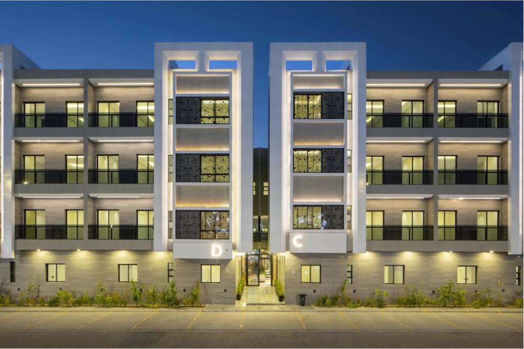 Hotel شقة فاخرة ذكية بمسبح وجيم Modern Luxury Smart Apartment with Pool & Gym, a large white building with its lights on at شقة فاخرة ذكية بمسبح وجيم Modern Luxury Smart Apartment with Pool & Gym in Riyadh